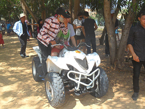 Khách tham gia dịch vụ chạy xe mô hình trên cát tại Bàu Trắng