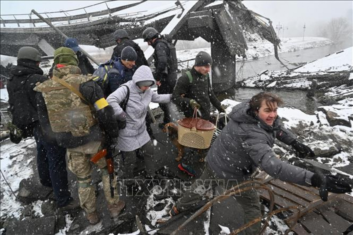Binh sĩ Ukraine hỗ trợ người sơ tán khỏi thành phố Irpin, phía Tây Bắc thủ đô Kiev ngày 8/3/2022. Ảnh: AFP/TTXVN