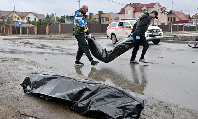 Nhân viên công chính Ukraine đưa túi được cho là đựng thi thể dân thường ở Bucha lên xe ngày 3/4. Ảnh: AFP.